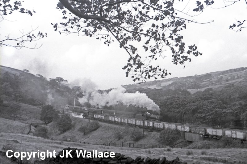 WD 90658 heads towards the entrance to Holme Tunnel and Rose Grove with a loaded coal train whilst the 13:30 Blackpool Central - Wakefield Kirkgate hauled by an unidentified Black 5.