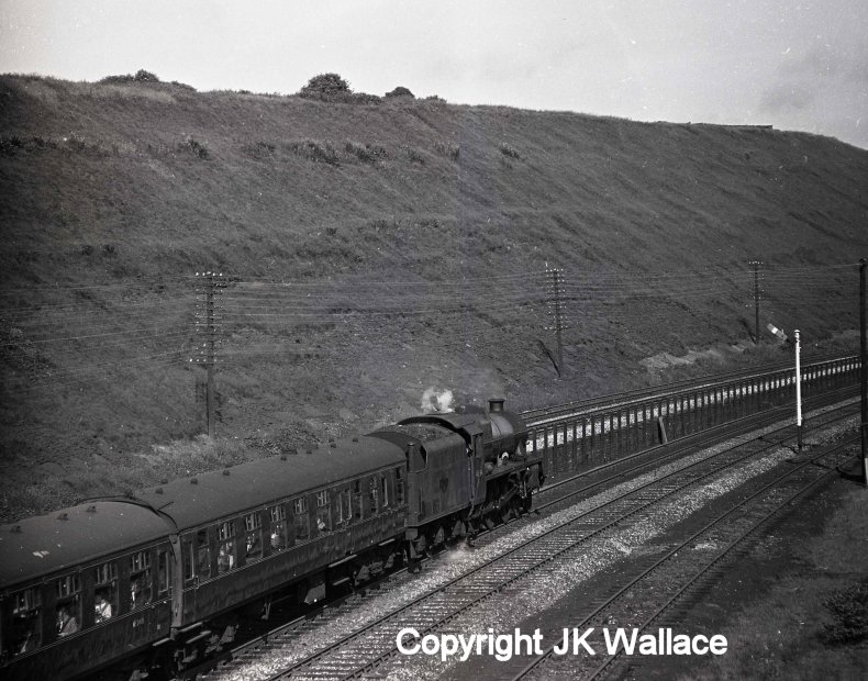 Stanier Jubilee 4-6-0 45694 'Bellerophon' is seen approaching Brighouse with the 08.05 Summer Saturdays only Castleford Central – Blackpool North at around 08.48 on Saturday 9 July 1966. The train is approaching on the slow lines, and has still to pass the exchange sidings before arriving at Brighouse Station. The train will have first passed Bradley Wood Junction and then Anchor Pit Junction to arrive here