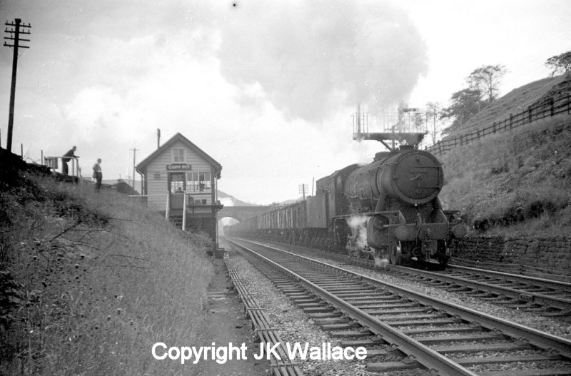 WD Austerity 2-8-0 90412 arrives at Copy Pit, having completed the climb up the Cliviger George from Stansfield Hall Junction in Todmorden some time in the early 1960s. Banker Crab 2-6-0 42727 can be seen under the road bridge still under steam. The train is bound for Rose Grove.