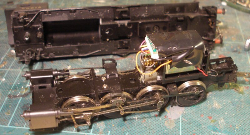 Bachmann WD 2-8-0 with body removed, and the original Lenz 1025 hard wired and taped in position above the motor.