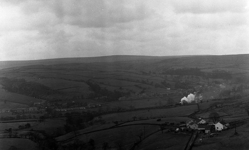 A WD 2-8-0 slogs towards Copy Pit from Burnley with 52 empty mineral wagons and a brake van.