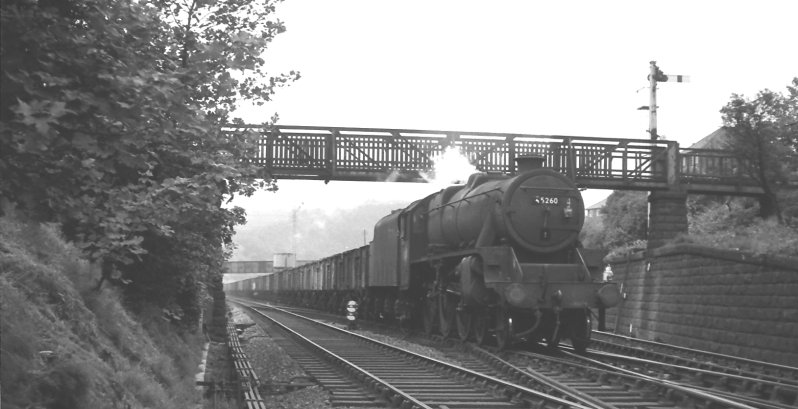 Black 5 45260 enters the Hall Royd Junction crossing with a returning train of empty coal wagons bound for Yorkshire in 1960. Passing under Lower Laithe House footbridge, then still in situ.