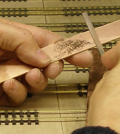 The strip is roughened with a file to ensure a good purchase by the solder.