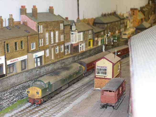 Bachmann Class 40 passes a row of shops based on a prototype in Burnley Row, Todmorden.