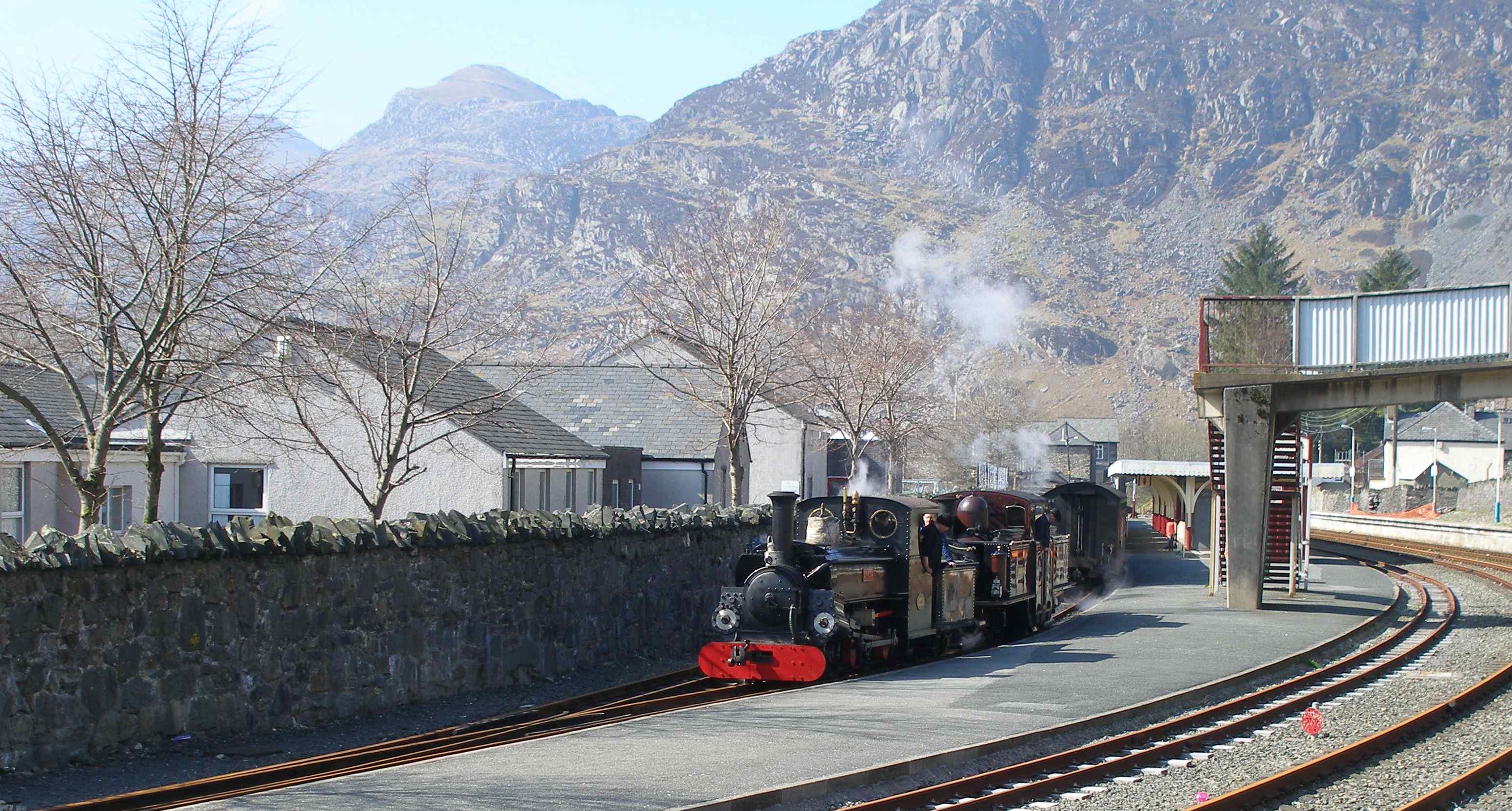 'Merddin Emrys' and 'Linda' running round at Blaenau Ffestiniog. The Network Rail standard gauge line in the foreground once ran through to Bala and Bala Junction; latterly servicing the power station at Trawsfynydd, and now terminates at a buffer stop to form a headshunt. Track remains to the Power Station, and has recently been cleared by local volunteers as part of a rail cycle tourist attraction proposal, although the infrastructure would require a major maintenance effort for trains to be restored. 