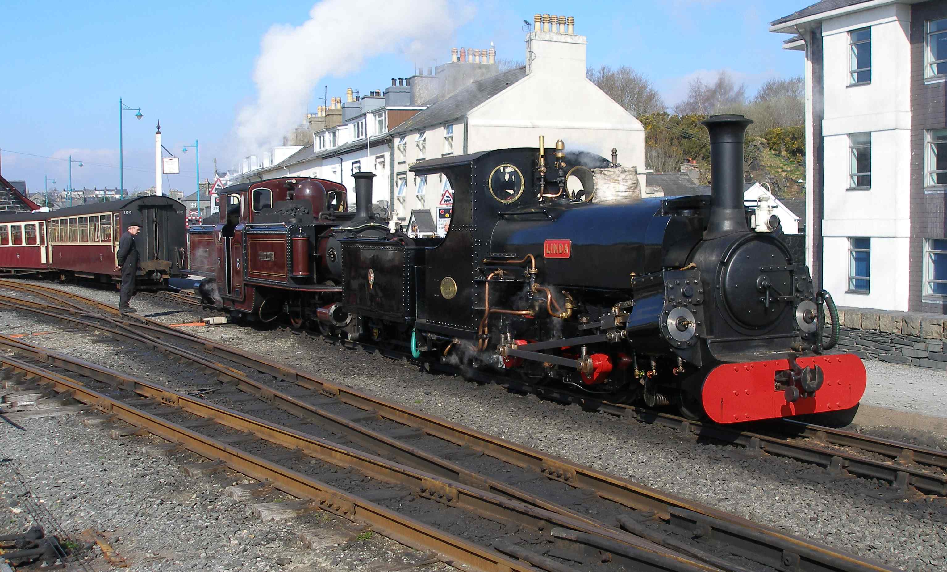 'Linda' and 'Merddin Emrys' make a fine sight as they back down on to their train at Porthmadog Harbour Station. This area here is now being redeveloped to create a new platform for Welsh Highland Railway trains to be terminated. This has involved widening the embankment and relocating the wave wall constructed in 1940. The new signal box and relay room are now located behind and to the left of the photographer. The new scheme will feature lower quadrant semaphore signals and the restoration of a 'trident' - the original was brought down from Blaenau in 1923 but was finally blown down in the late 1960s.