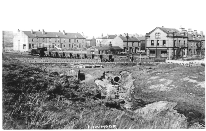 Postcard of Low Moor showing standard gauge loco pulling a train of narrow gauge waggons