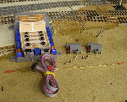 The Minx point and signal actuator kit laid out to show control unit, ribbon cables, control rods, actuators and screws