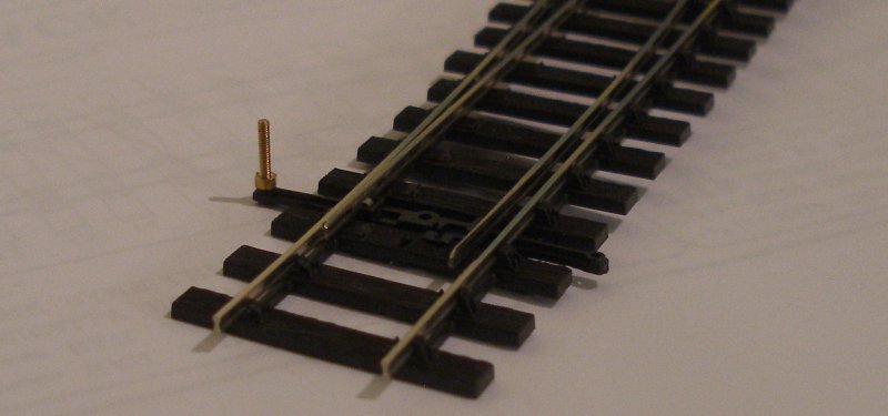 PECO Streamline Bullhead OO scale Code 75 Unifrog point (turnout) showing the installation of a 10 BA nut and bolt to allow operation using the PECO above-baseboard solenoid motor mountings.