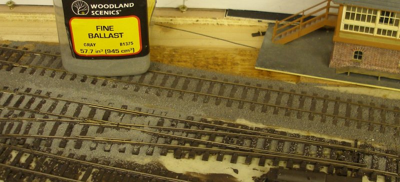 Ballast being brushed around the sleepers of the PECO Streamline Bullhead OO scale Code 75 Unifrog point (turnout) after it had been laid on the layout.