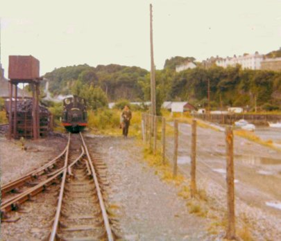 Festiniog Railway 0-4-0 ST No 2 Prince stands next to the water tank at Portmadoc one morning in late July 1966
