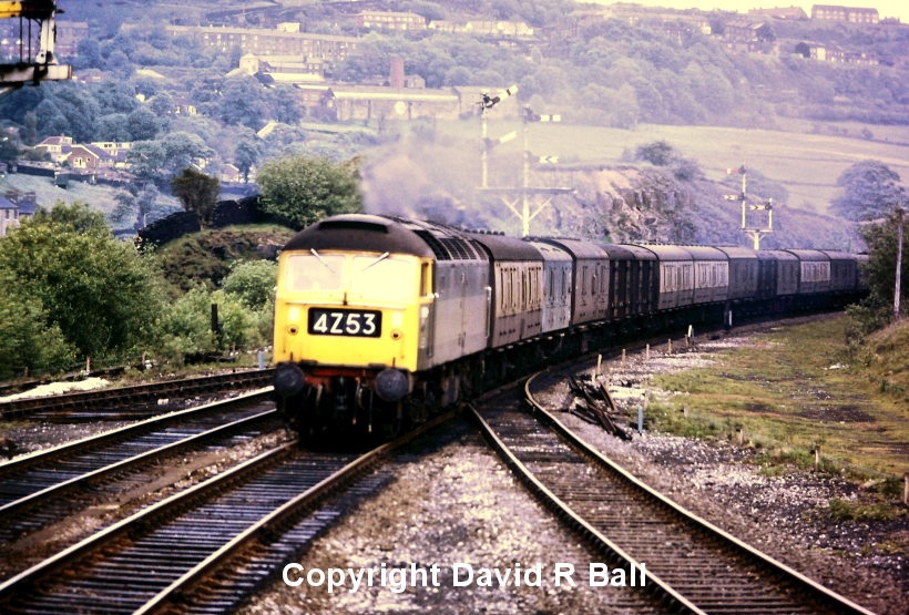 Sowerby Bridge railway station 1971: a view from the signal box. A Class 47 heads a long train of parcel vans, led by a Mark 1 BG and 4-wheeled CCT van. Given the length of this train, it is probably the Heaton - Red Bank empty newspaper vans that ran up the Calder Valley in the late afternoon. Sadly, this train was discontinued once Murdoch took control of various newspaper groups and sought reduced costs. 