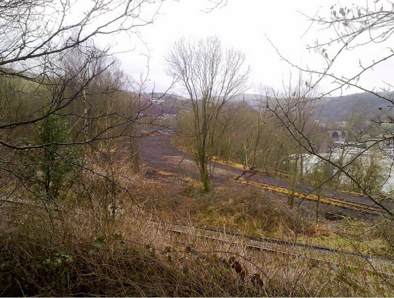 9 March 2012: Andrew Stopford's photograph shows the site of short curve linking the Calder Valley line to the Copy Pit line cleared ready to be re-instated. The Copy Pit line is crossing left to right in the foreground, and the viaduct leading to Todmorden Station, which carries the existing Calder Valley line, is visible centre right. The re-instated line will follow the excavated and cleared dark coloured formation curving towards the viaduct.