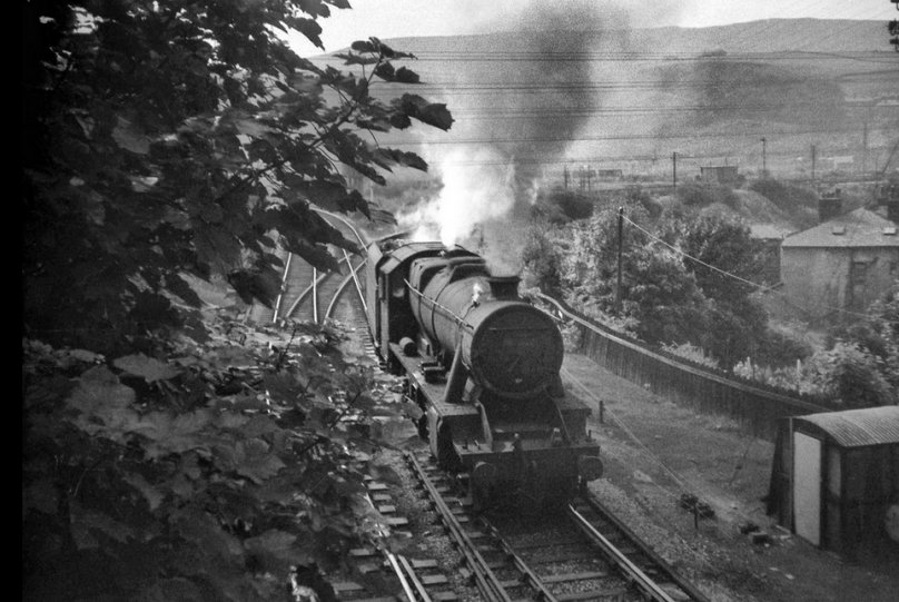 LMS Stanier 8F 2-8-0 48519 of Rose Grove shed heads out of the sun at Stansfield Hall Todmorden to buffer up to a Class 40 diesel-hauled coal train and bank it up to Copy Pit summit on the Burnley line on 1 August 1968, with only two more days to go for the Copy Pit bankers.