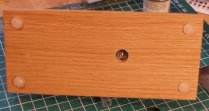 Underside of plinth showing recessed hole and bolt holding Pannier to oak plinth